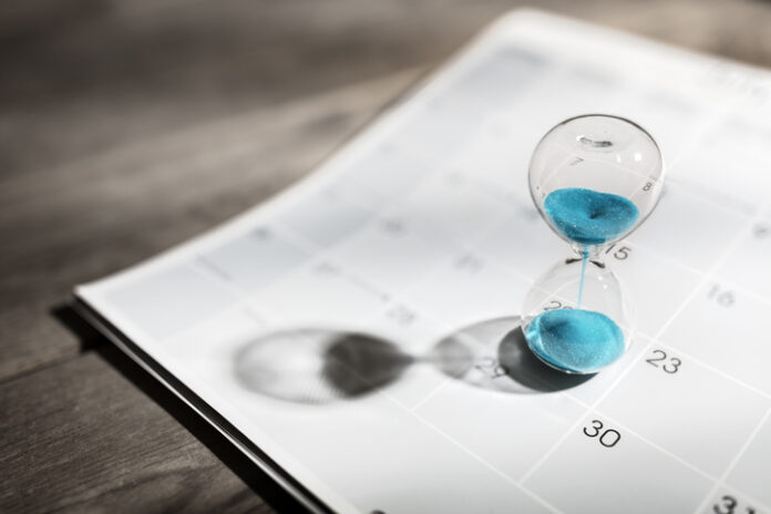 Hourglass on calendar appointment date, schedule and deadline